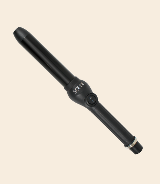 soleil black curling iron with one power button, black barrel with 32mm, silver details against a light beige background