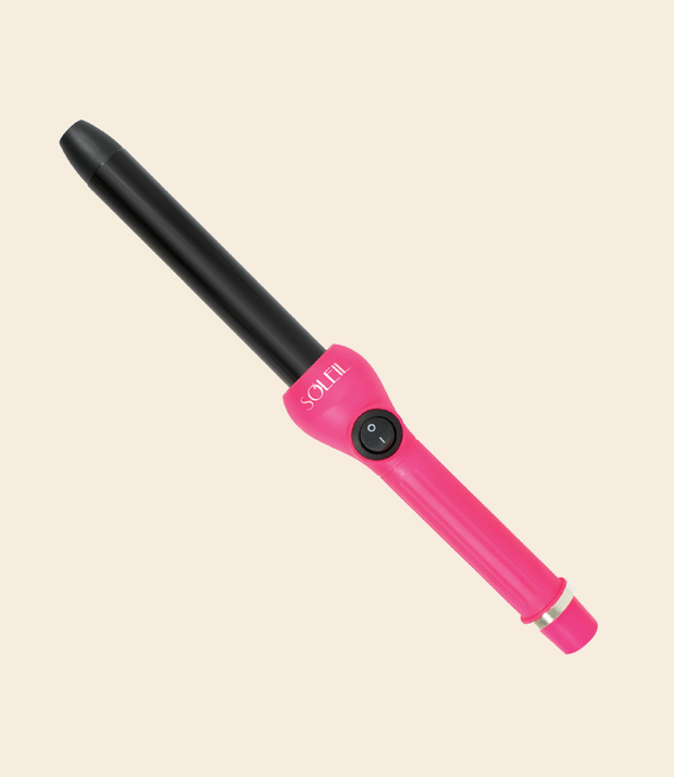 soleil curling iron with one power button, black barrel with 25mm, pink handle and silver details against a light beige background
