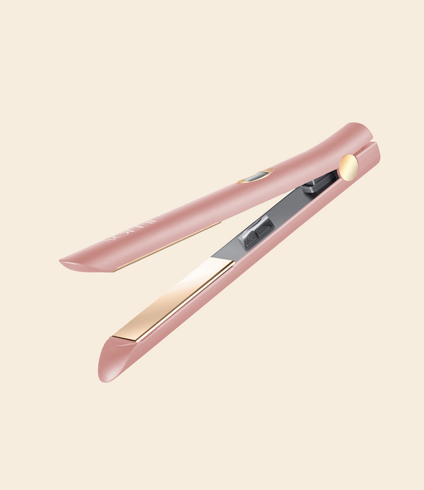 soleil rose gold Infrared flat iron with gold plates and gold and black detail against a light beige background